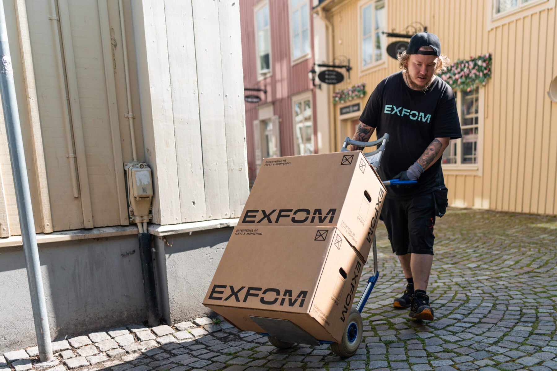 EXFOM:s personal kör flyttkartonger på en säckkärra